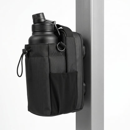 An isometric angled profile view of the black Aveliques Magnetic Gym Bag showing the multiple magnetic plates on the back, temporarily attached to a metal plate, demonstrating its function, on a seamless white background.